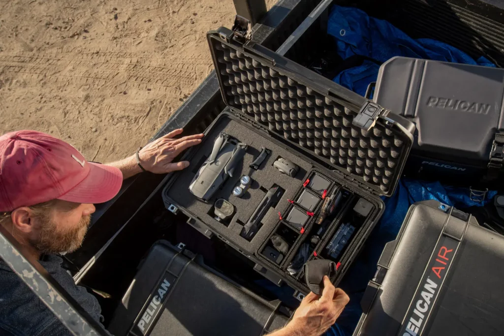 homem guardando equipamentos em case para drone